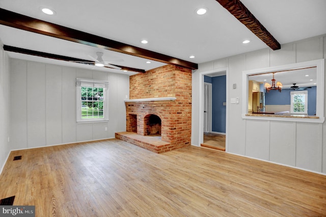 3228 Canterbury Ln, Fallston, MD 21047 - unfurnished living room featuring a decorative wall, beam ceiling, a ceiling fan, wood finished floors, and a chandelier