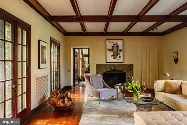 living area featuring wood finished floors, beam ceiling, french doors, a high end fireplace, and baseboards