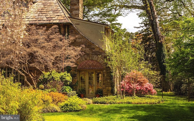 view of home's exterior with stone siding, a chimney, and stucco siding