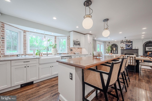 312 Center Hill Rd, Wilmington, DE 19807 - kitchen with a sink, appliances with stainless steel finishes, white cabinetry, dark wood-type flooring, and pendant lighting
