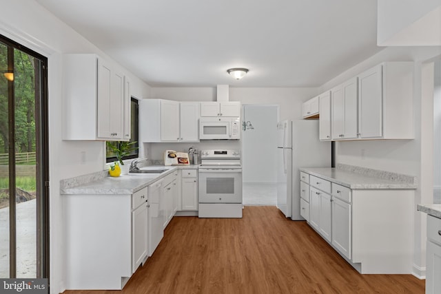 5338 Lightning View Rd, Columbia, MD 21045 - kitchen featuring white appliances, a sink, wood finished floors, white cabinets, and light countertops