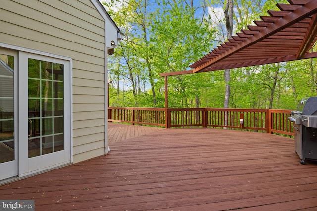 wooden deck with area for grilling and a pergola