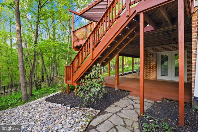 view of patio with french doors, fence, a wooden deck, and stairs