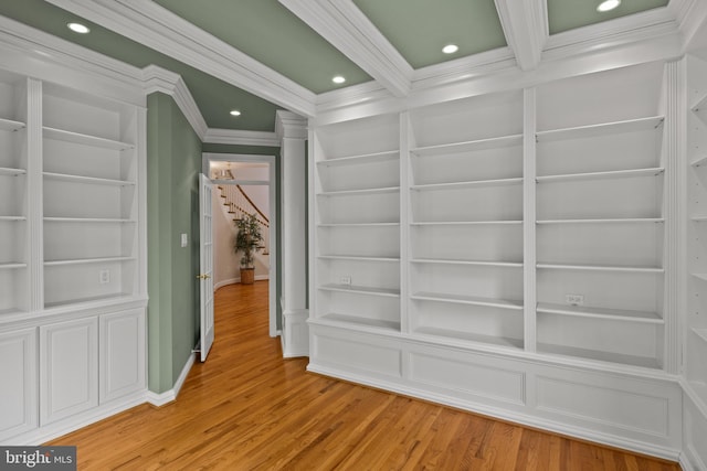 interior space with built in features, ornamental molding, recessed lighting, and wood finished floors