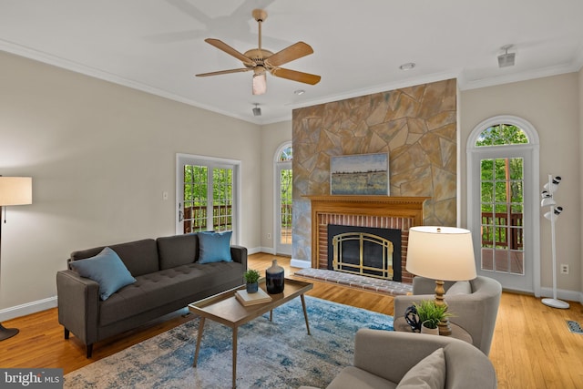 living room with baseboards, ornamental molding, a ceiling fan, and wood finished floors