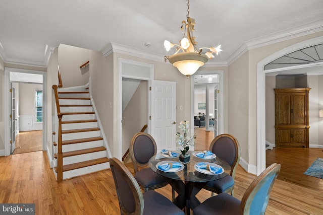 dining room featuring ornamental molding, stairs, baseboards, light wood-type flooring, and a chandelier