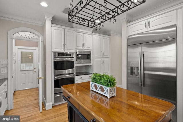 kitchen with crown molding, white cabinets, built in appliances, wood counters, and light wood-type flooring