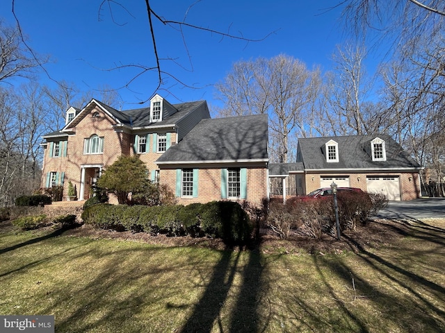 view of front of home featuring a garage, a front yard, and brick siding
