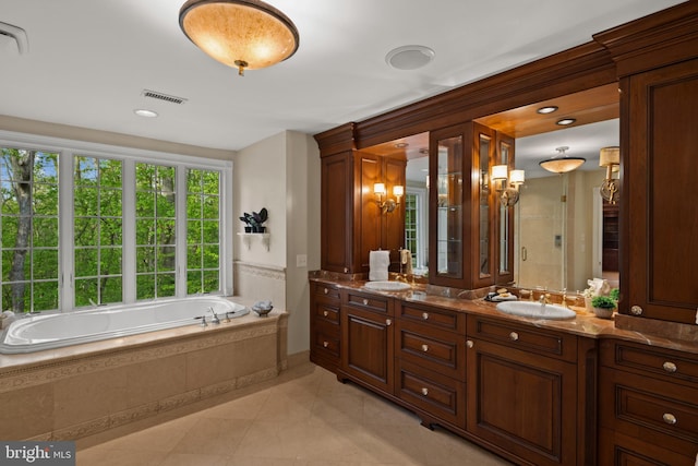 bathroom featuring double vanity, tile patterned floors, a sink, and a bath