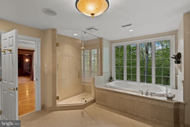 bathroom with tile patterned flooring, a garden tub, a stall shower, and visible vents