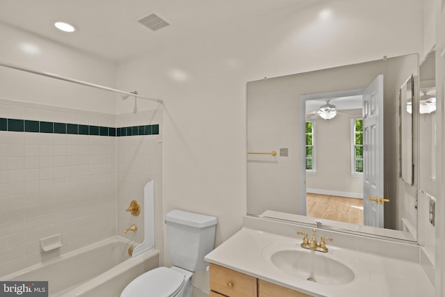 bathroom with ceiling fan, visible vents, vanity, toilet, and  shower combination