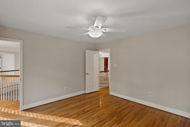 unfurnished room with baseboards, ceiling fan, and wood finished floors