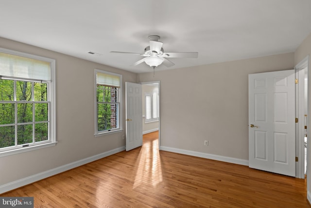 interior space with baseboards, visible vents, a wealth of natural light, and light wood finished floors
