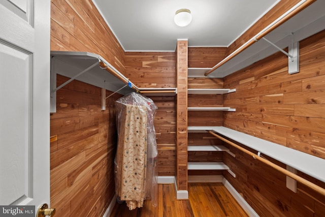 walk in closet with wood finished floors