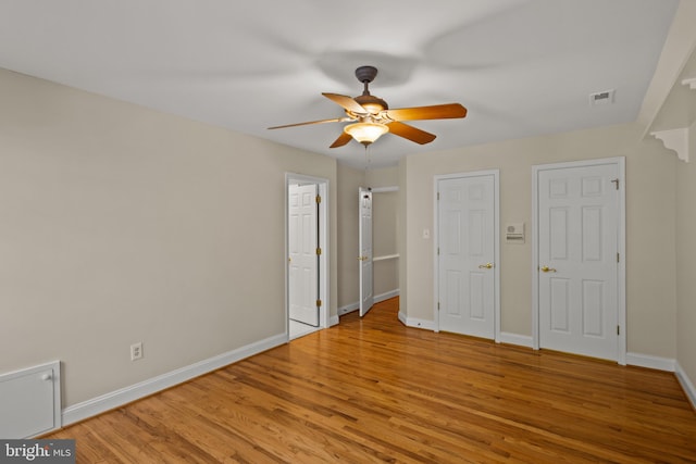 unfurnished bedroom with light wood-style floors, baseboards, ceiling fan, and visible vents