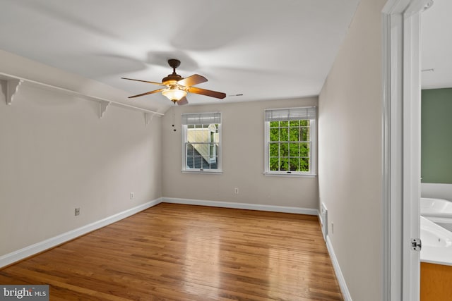 unfurnished bedroom with a ceiling fan, baseboards, visible vents, and wood finished floors