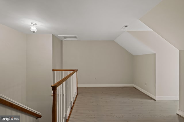 bonus room with visible vents, lofted ceiling, light wood-style floors, attic access, and baseboards