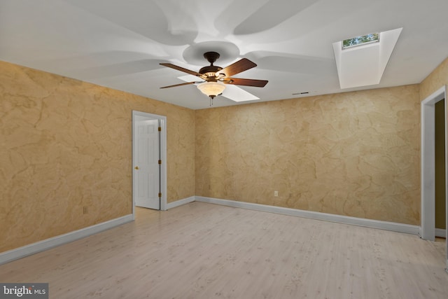 empty room with baseboards, ceiling fan, and wood finished floors