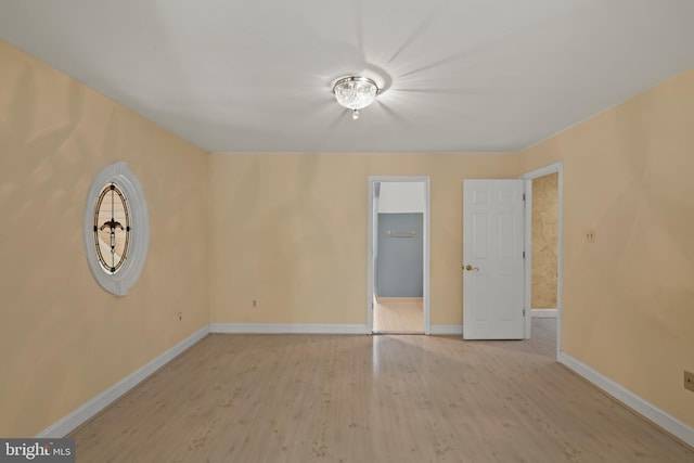 empty room featuring baseboards and light wood-type flooring