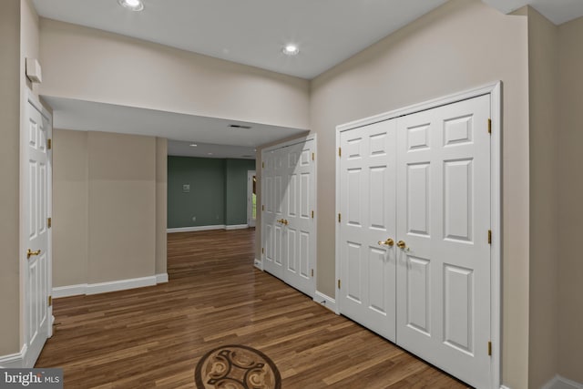 hallway featuring baseboards, recessed lighting, wood finished floors, and visible vents