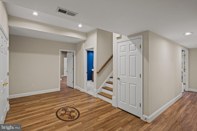 interior space featuring stairs, recessed lighting, baseboards, wood finished floors, and visible vents