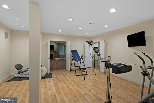 exercise room with light wood-style floors, baseboards, recessed lighting, and visible vents