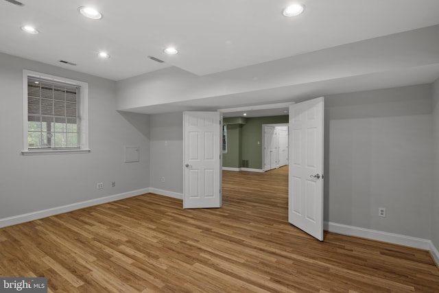 basement featuring baseboards, recessed lighting, wood finished floors, and visible vents