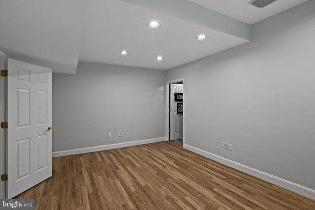 empty room featuring baseboards, recessed lighting, wood finished floors, and visible vents