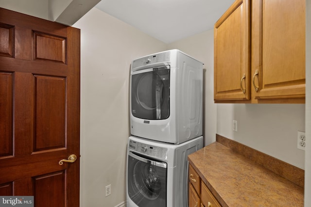 laundry area with stacked washing maching and dryer and cabinet space