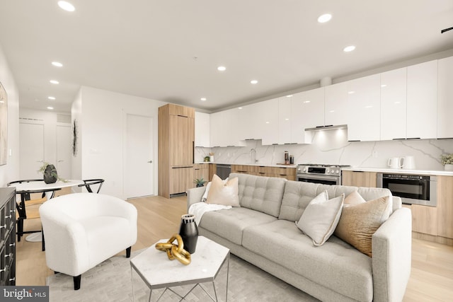 living room with light wood-style floors and recessed lighting