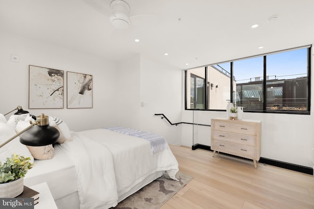 bedroom with baseboards, light wood finished floors, and recessed lighting