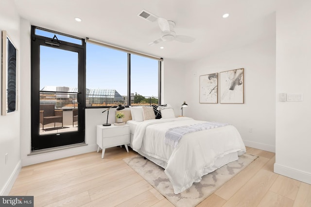 bedroom featuring expansive windows, wood finished floors, baseboards, visible vents, and recessed lighting