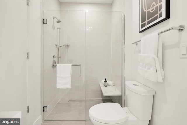 bathroom with toilet and a stall shower