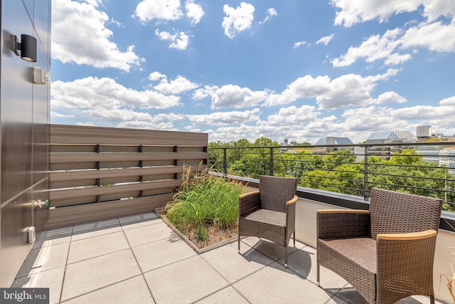 view of patio / terrace with a balcony and a view of city