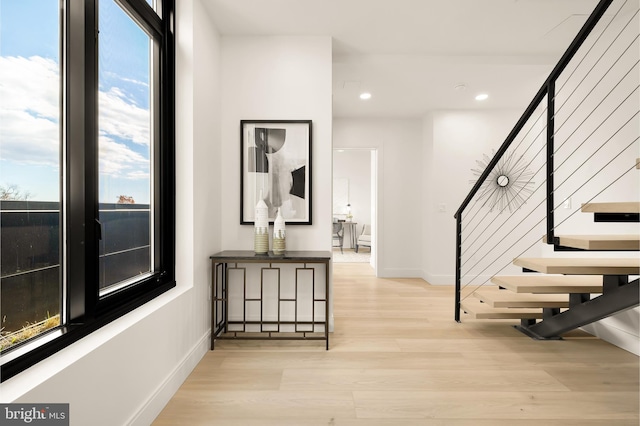 interior space featuring recessed lighting, baseboards, stairs, and wood finished floors