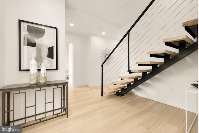 stairway with recessed lighting, baseboards, and wood finished floors