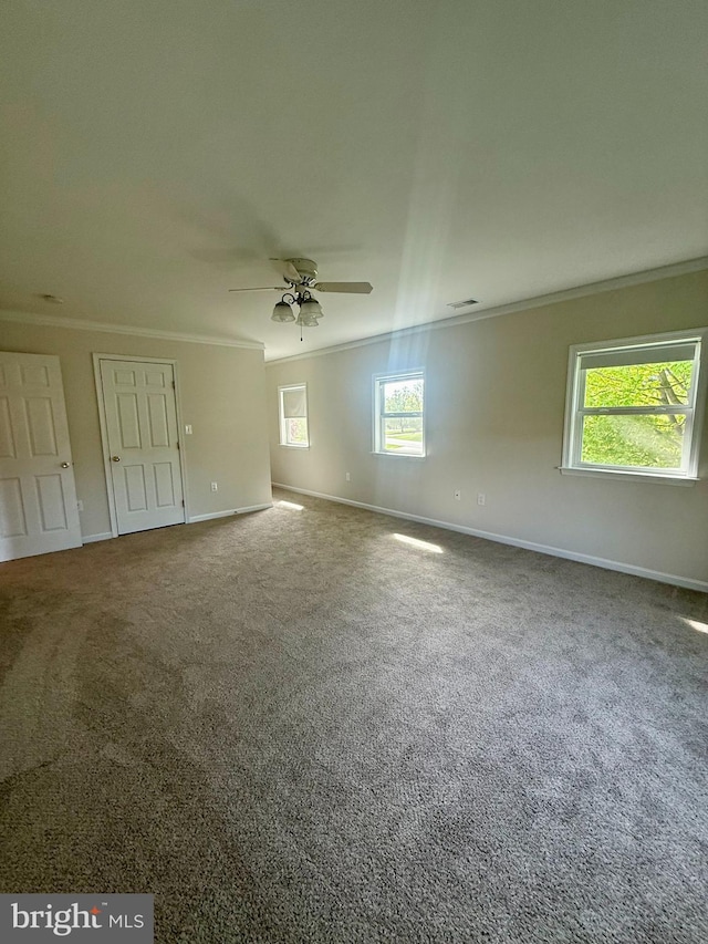 spare room featuring ornamental molding, a ceiling fan, carpet, and baseboards