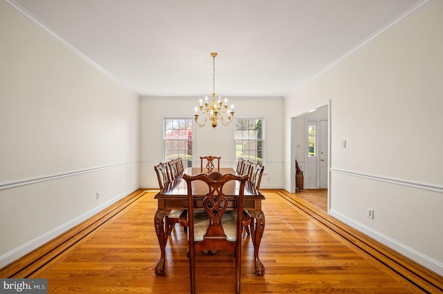 dining room with a wealth of natural light, an inviting chandelier, crown molding, and light wood-style flooring