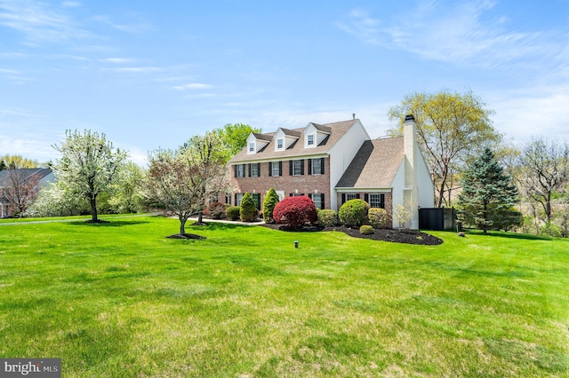 view of front facade with a front lawn, brick siding, and a chimney
