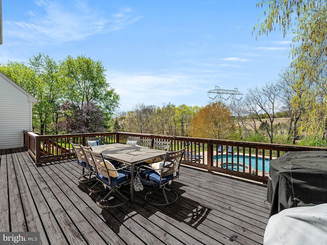 wooden terrace with outdoor dining area and an outdoor pool