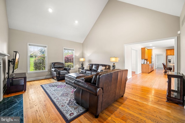 living room featuring light wood-type flooring, recessed lighting, and high vaulted ceiling