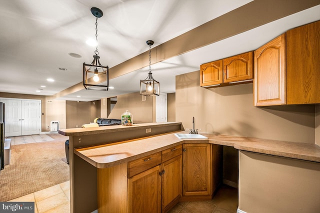 kitchen with light tile patterned floors, a peninsula, and a sink