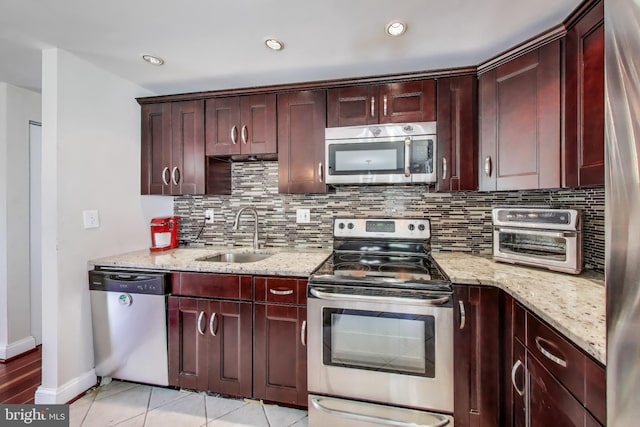 7910 E Nalley Rd, Hyattsville, MD 20785 - kitchen with stainless steel appliances, a sink, decorative backsplash, baseboards, and light stone countertops