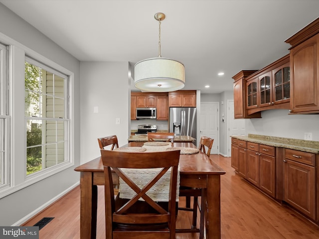 dining space with light wood finished floors, recessed lighting, and baseboards