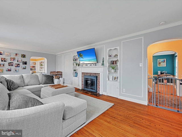 341 Creston Rd, York, PA 17403 - living area with a fireplace, arched walkways, ornamental molding, wood finished floors, and built in shelves