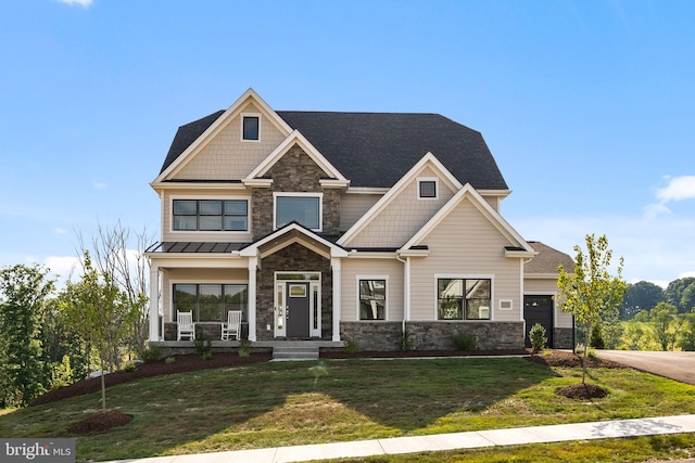 view of front of house featuring a front yard, stone siding, and roof with shingles