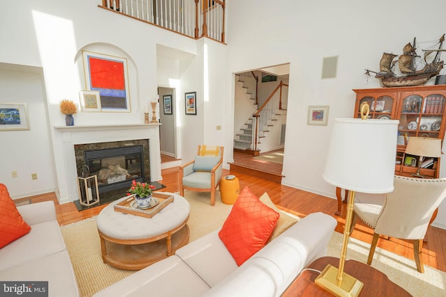 13470 Harrison Landing Rd, Princess Anne, MD 21853 - living area featuring a towering ceiling, wood finished floors, stairway, and a premium fireplace