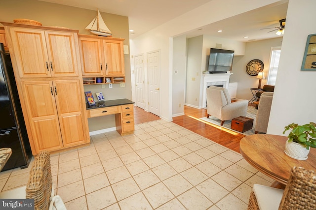 13470 Harrison Landing Rd, Princess Anne, MD 21853 - kitchen featuring light tile patterned flooring, a premium fireplace, open floor plan, built in study area, and light brown cabinetry