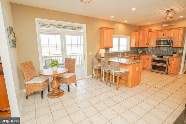 13470 Harrison Landing Rd, Princess Anne, MD 21853 - kitchen featuring a peninsula, appliances with stainless steel finishes, recessed lighting, and decorative backsplash
