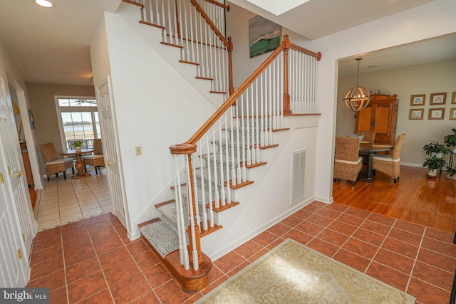 13470 Harrison Landing Rd, Princess Anne, MD 21853 - stairs featuring tile patterned flooring, baseboards, a chandelier, and visible vents